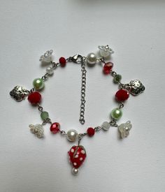 handmade strawberry charm bracelet ♡ made with glass beads, pearl beads, zinc alloy charms, a stainless steel lobster clasp, and stainless steel silver wire.  CARE INSTRUCTIONS - please keep away from perfumes, oils, creams, and water  - avoid tugging or pulling on jewelry SOCIALS - instagram @butterflyinbloomco - tiktok @butterflyinbloomco dm if you have any questions or if you are interested in a custom order!  not responsible for lost or damaged mail Diy Bracelet With Charm, Strawberry Charm Bracelet, Cheap Handmade Red Charm Bracelet, Bracelet Theme Ideas, Clay Beads Jewelry Ideas, Charm Bracelet Aesthetic, Handmade Charm Bracelets, Strawberry Charm, Diy Charm Bracelet