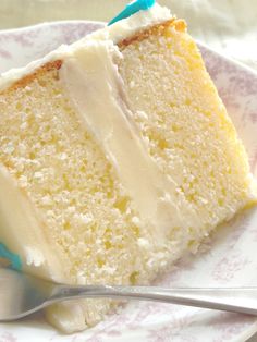 a slice of white cake on a plate with a blue and white fork next to it