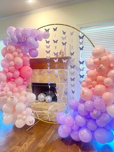 balloons are arranged in the shape of flowers and butterflies on a table with a fireplace