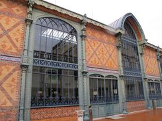 an old brick building with ornate iron work on the windows