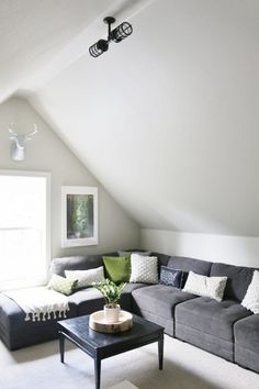 a living room with gray couches and white walls