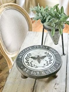 a small potted plant sitting on top of a wooden table next to a chair