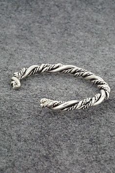 This "braided" sterling silver bracelet was made by Navajo silversmith Elaine Tahe.Size: 5" (will fit up to a 6 1/4" wrist)Gap: 1 1/4"Width: 1/4"Free shipping on all orders! We ship with USPS and always include tracking. All orders ship within a day of payment.Returns are accepted up to 30 days after you receive your order. Just send us a message. Our shop offers cash back or store credit. The item must be returned in new condition. Silver Sterling Braided Bracelets, Braided Sterling Silver Bracelet, Handmade Sterling Silver Braided Bohemian Bracelets, Handmade Sterling Silver Bohemian Braided Bracelets, Silver Adjustable Twisted Bracelets, Adjustable Twisted Silver Bracelets, Silver Braided Bangle Bracelets, Silver Bohemian Braided Bangle Bracelet, Bohemian Silver Braided Bangle Bracelet