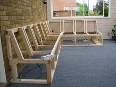 a row of wooden benches sitting on top of a blue carpeted floor next to a window