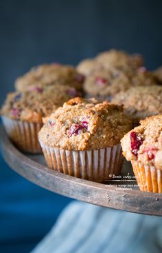 muffins with cranberries are on a wooden tray, ready to be eaten