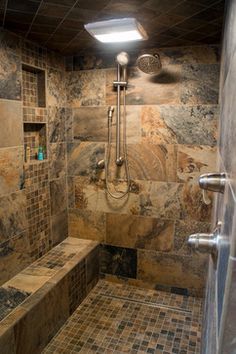 a walk in shower sitting next to a tiled wall