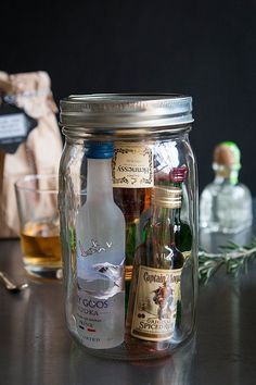 a glass jar filled with liquor sitting on top of a table