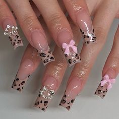 a woman's nails with leopard print and pink bows