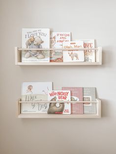 two wooden shelves with books on them against a wall in a children's room