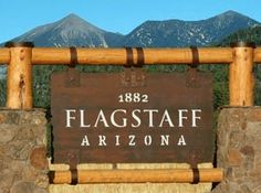 a sign for flagstaff arizona with mountains in the background