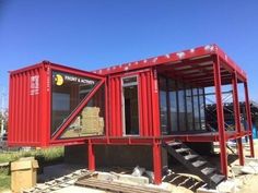 a red shipping container sitting on the side of a road with stairs leading up to it