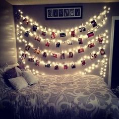 a bed with lights strung over it and pictures on the wall