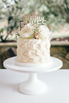 a white wedding cake with flowers on top