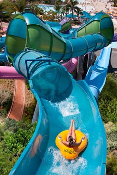 a man riding on the back of a blue water slide