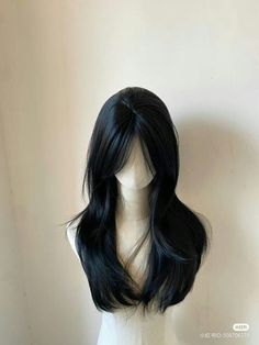 a wig with long black hair sitting on top of a mannequin's head