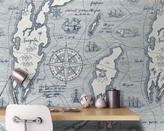 a desk with a chair, lamp and map wallpaper on the wall behind it