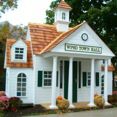 a small white building with a clock on the top