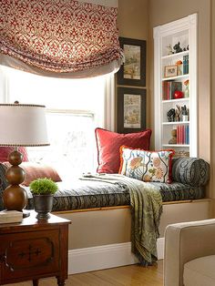 a window seat in the corner of a room with bookshelves on either side