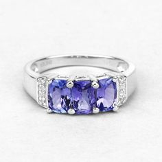 Tanzanite Ring, Real 3-Stone Tanzanite and Diamond Sterling Silver Ring, Tanzanite Cushion Silver Ring, Bridesmaid Gift, December Birthstone.925 Sterling SilverStone Details: TanzaniteItem Type: RingSubcategory: TanzaniteGross Wt: 2.83Gemstone Wt: 1.59 ctwDiamond Wt: 0.04 ctwTotal Stone Wt: 1.63 ctwMetal Stamp: 925 QJ™ INFinish: Rhodium PlatedProduct Style: 3 Stone RingTotal Qty Of Stones: 11Height: 25.18 MMWidth: 16.21 MMLength: 6.43 MMPrimary Stone Color: VioletBirthstone Month: DecemberGender Tanzanite Birthstone Rings, Three Stone Sapphire Ring Gift, Anniversary Three Stone Gemstone Ring, Tanzanite Diamond Ring As A Gift, Tanzanite Three Stone Wedding Jewelry, Tanzanite Jewelry With Accent Stones For Promise, Three Stone Tanzanite Rings For Anniversary, Three Stone Tanzanite Jewelry As Gift, Tanzanite Three Stone Rings For Anniversary