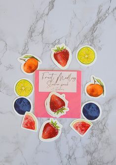 the fruit magnets are arranged in a circle on top of a marble countertop