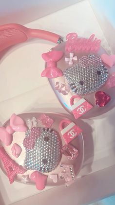 two hello kitty toothbrushes with pink and silver decorations on them sitting in a box