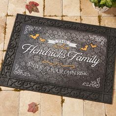 a black door mat that says the hendu's family on it and leaves around it