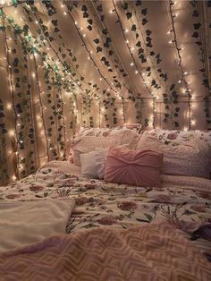 a bed covered in lots of lights and pillows