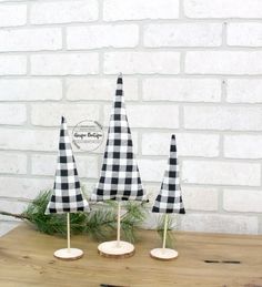 three black and white checkered umbrellas sitting on top of a wooden table