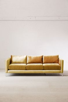 a yellow couch sitting on top of a white floor