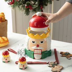 a person is decorating a nutcracker on a table with other christmas decorations