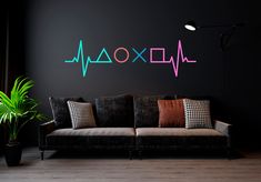 a living room with a couch, plant and wall decal