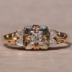 an antique diamond ring is shown on a wooden surface