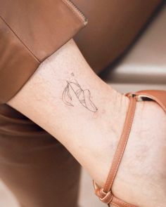 a woman's foot with a small tattoo on the left side of her ankle