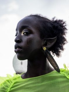 a woman with dark skin wearing large earrings