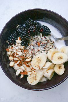 a bowl filled with fruit and nuts on top of a white countertop next to a knife