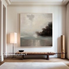 a painting hanging on the wall above a bench in a room with white walls and flooring