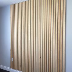 an empty room with wooden slats on the wall