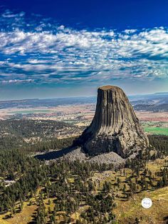 an aerial view of a large rock formation in the middle of a forest with trees around it