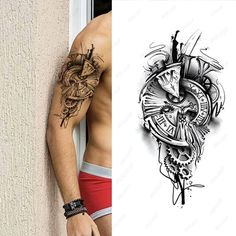 a man is standing next to a wall with tattoos on his arm and chest,