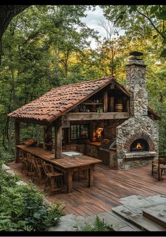 a wooden deck with an outdoor fireplace and grill in the middle, surrounded by trees