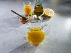 a pitcher filled with liquid sitting on top of a table next to other bottles and spoons