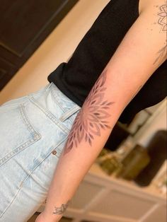 a woman's arm with a tattoo on it, and a flower in the middle