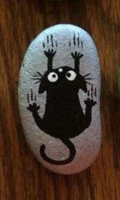 two rocks with black cats painted on them