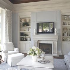 a living room filled with furniture and a flat screen tv mounted to a wall above a fire place