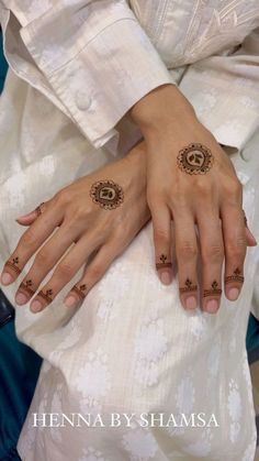 two hands with henna tattoos on them