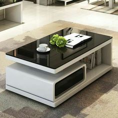 a modern coffee table with a glass top in the middle of an open living room