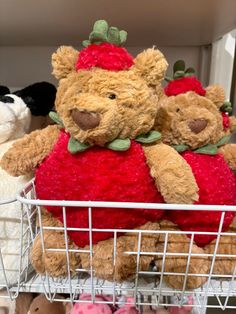 several stuffed animals sitting in a wire basket on top of a shelf next to each other