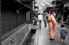 a woman and child are walking down the street