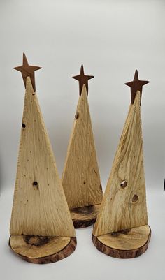 three wooden christmas trees with stars on them