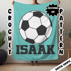 a woman holding up a blanket with a soccer ball on it that says crochet me